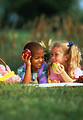 Free Stock Photo: Young children eating apples while having a picnic on the grass