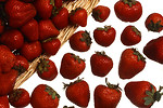 Free Stock Photo: A basket full of strawberries spilling on a white background