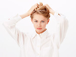 Free Stock Photo: A beautiful blonde fixing her hair isolated on a white background