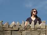 Free Stock Photo: A beautiful girl standing behind a stone wall