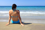 Free Stock Photo: A beautiful woman sitting on the beach looking at the ocean