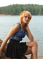 Free Stock Photo: A beautiful young woman posing on a rock by a lake