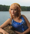 Free Stock Photo: A beautiful young woman posing on a rock by a lake.