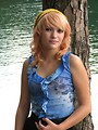 Free Stock Photo: A beautiful young woman posing against a tree by a lake