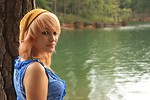 Free Stock Photo: A beautiful young woman posing against a tree by a lake