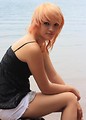 Free Stock Photo: A beautiful young woman posing on a rock by a lake