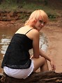 Free Stock Photo: A beautiful young woman posing on a log by a lake