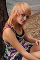 Free Stock Photo: A beautiful young woman posing against a tree by a lake