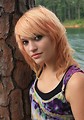 Free Stock Photo: A beautiful young woman posing against a tree by a lake