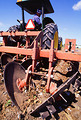 Free Stock Photo: A farmer driving a tractor pulling a stalk-puller