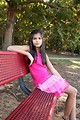 Free Stock Photo: A beautiful young girl sitting on a bench outdoors