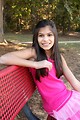 Free Stock Photo: A beautiful young girl sitting on a bench outdoors