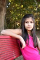 Free Stock Photo: A beautiful young girl sitting on a bench outdoors