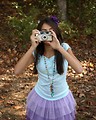 Free Stock Photo: A cute young girl playing with a camera outdoors