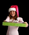 Free Stock Photo: A beautiful young girl in a pink santa hat holding a present