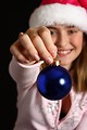 Free Stock Photo: A beautiful young girl in a pink santa hat holding a blue ornament