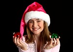 Free Stock Photo: A beautiful young girl in a pink santa hat holding Christmas tree ornaments