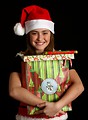 Free Stock Photo: A cute young girl in a Santa hat holding a bag of presents