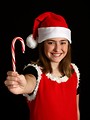 Free Stock Photo: A cute young girl in a Santa hat holding a candy cane