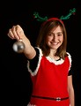 Free Stock Photo: A cute young girl in a Christmas outfit holding an ornament