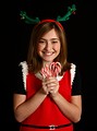 Free Stock Photo: A cute young girl in a Christmas outfit holding candy canes
