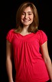 Free Stock Photo: A cute young girl in a pink shirt posing on a black background