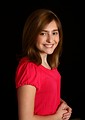Free Stock Photo: A cute young girl in a pink shirt posing on a black background