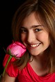 Free Stock Photo: A cute young girl posing with a pink rose