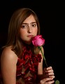 Free Stock Photo: A cute young girl posing with a pink rose