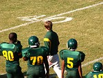 Free Stock Photo: Football players and a coach on a field