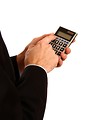 Free Stock Photo: A young businessman in a suit using a calculator.