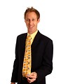 Free Stock Photo: A young businessman in a suit showing off his tie