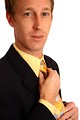 Free Stock Photo: A young businessman in a suit adjusting his tie