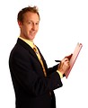 Free Stock Photo: A young businessman in a suit writing on a clipboard