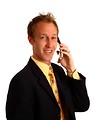 Free Stock Photo: A young businessman in a suit talking on a cell phone