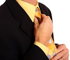 Free Stock Photo: A young businessman in a suit adjusting his tie