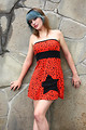 Free Stock Photo: A beautiful young woman posing in a red dress against a stone wall