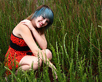 Free Stock Photo: A beautiful young woman posing in a red dress in tall grass