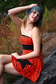 Free Stock Photo: A beautiful young woman posing in a red dress on rocks
