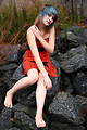 Free Stock Photo: A beautiful young woman posing in a red dress on rocks