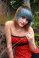 Free Stock Photo: A beautiful young woman posing in a red dress on rocks
