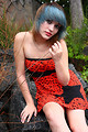Free Stock Photo: A beautiful young woman posing in a red dress on rocks