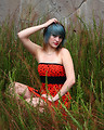 Free Stock Photo: A beautiful young woman posing in a red dress in tall grass