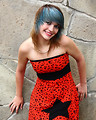 Free Stock Photo: A beautiful young woman posing in a red dress against a stone wall