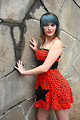 Free Stock Photo: A beautiful young woman posing in a red dress against a stone wall