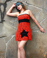 Free Stock Photo: A beautiful young woman posing in a red dress against a stone wall