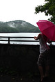 Free Stock Photo: A beautiful young woman posing with an umbrella by a lake