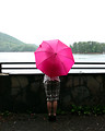 Free Stock Photo: A beautiful young woman looking over a lake holding an umbrella