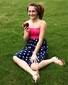 Free Stock Photo: A beautiful young girl holding an apple in the grass
