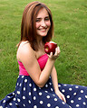 Free Stock Photo: A beautiful young girl holding an apple in the grass